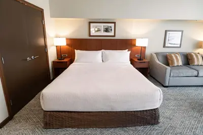 a hotel room with a large bed and a couch at Sutton Place Hotel Revelstoke Mountain Resort in Revelstoke