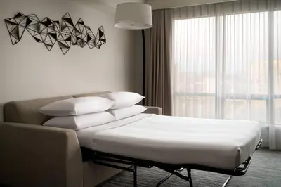a room with a bed and a couch and a window at Vancouver Airport Marriott Hotel in Richmond