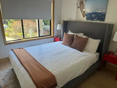 a bed in a bedroom with a large window at Powderhorn by Whistler Blackcomb Vacation Rentals in Whistler