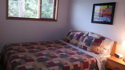 a bedroom with a bed with a quilt on it at Invermere 4 Br Lakeside, Mountain View Home! Walk to Sandy Beach for Swimming, Boating, Tennis and Beach Volleyball Local Town Shopping, Eateries, Bakery and Pubs! Welcome Family's, Healthcare Workers and Trades! Monthly Rentals of 28 Nights or More! in Invermere