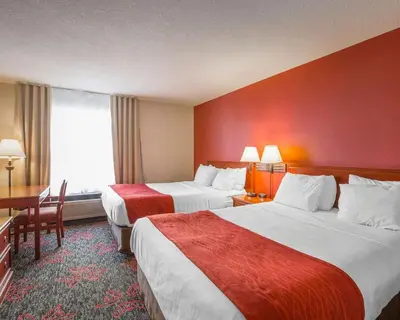 a hotel room with two beds and a desk at Comfort Inn & Suites University in Calgary
