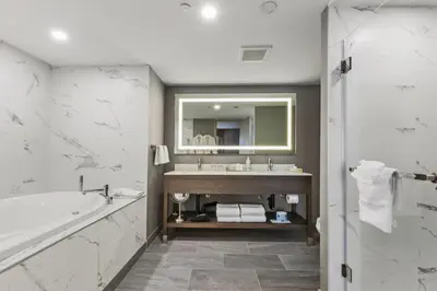 a bathroom with a tub and a sink and a mirror at Best Western Premier Calgary Plaza Hotel & Conference Centre in Calgary