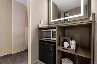 a small kitchen with a microwave and a refrigerator at Best Western Premier Calgary Plaza Hotel & Conference Centre in Calgary