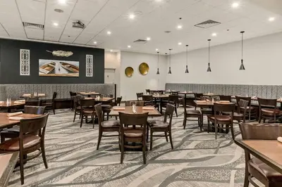 a dining room with wooden tables and chairs at Best Western Premier Calgary Plaza Hotel & Conference Centre in Calgary