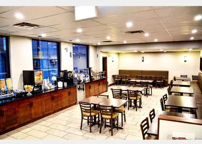 a restaurant with tables and chairs and a bar at Super 8 by Wyndham Kelowna BC in Kelowna