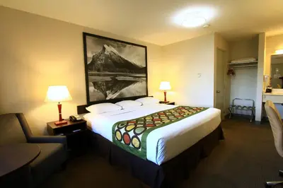 a hotel room with a large bed and a couch at Super 8 by Wyndham Kelowna BC in Kelowna