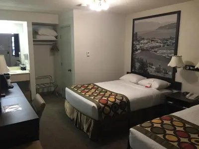 a hotel room with two beds and a desk at Super 8 by Wyndham Kelowna BC in Kelowna