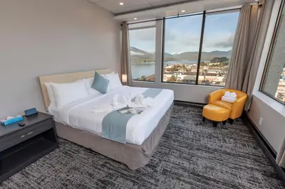 a hotel room with a bed and a large window at Highliner Hotel in Prince Rupert