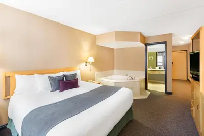 a hotel room with a bed and a bath tub at Ramada Plaza by Wyndham Prince George in Prince George