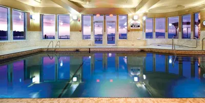 a swimming pool with blue water in a building at The Beach Club Resort — Bellstar Hotels & Resorts in Parksville