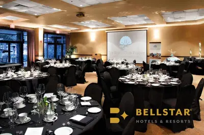 a conference room with tables and chairs and a screen at The Beach Club Resort — Bellstar Hotels & Resorts in Parksville