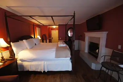 a hotel room with a large bed and a fireplace at South Thompson Inn & Conference Centre in Kamloops