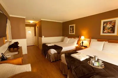 a hotel room with two beds and a television at South Thompson Inn & Conference Centre in Kamloops