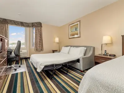 a hotel room with a bed and a chair at Holiday Inn Conference Centre Edmonton South by IHG in Edmonton