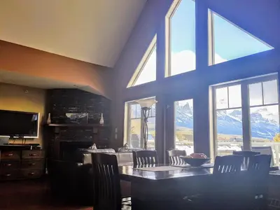 a dining room with a table and some windows at PRC Annex - Pet Friendly in Canmore