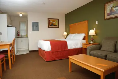 a hotel room with a bed and a couch and a table at Chateau Motel in Edmonton