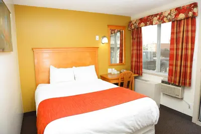 a bedroom with a large bed and a window at Chateau Motel in Edmonton