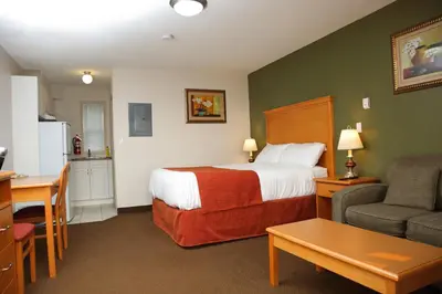 a hotel room with a bed and a couch and a table at Chateau Motel in Edmonton