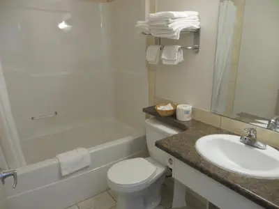 a bathroom with a sink and a toilet and a bath tub at Chateau Motel in Edmonton