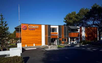 a building with a cost benefit sign in a parking lot at Coast Metro Vancouver Hotel in Burnaby