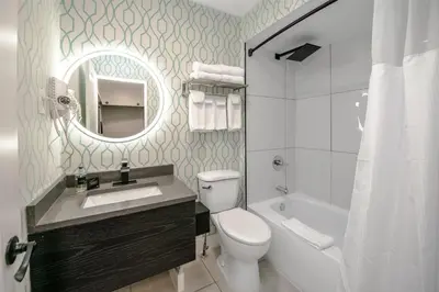 a bathroom with a sink and a toilet and a mirror at Coast Metro Vancouver Hotel in Burnaby