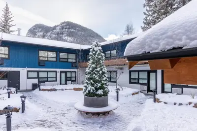 a building with a christmas tree in the snow at The Dorothy Motel in Banff