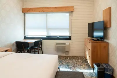 a bedroom with a bed and a television and a table at The Dorothy Motel in Banff