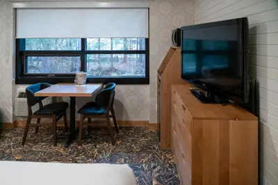 a room with a table and a television and a table and chairs at The Dorothy Motel in Banff