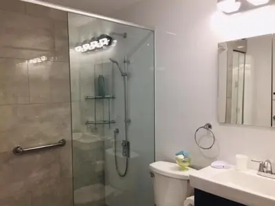 a bathroom with a shower and a toilet and a sink at Ocean Breeze Executive Bed and Breakfast in North Vancouver