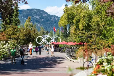 a group of people walking down a sidewalk in a park at Tyndall Stone Lodge by Whiski Jack in Whistler