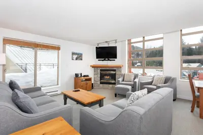 a living room with couches and a fire place at Lake Placid Lodge by Whiski Jack in Whistler
