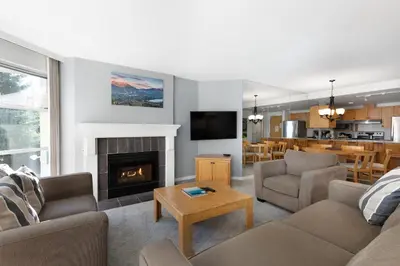a living room with a couch and a fireplace at The Woodrun Lodge by Whiski Jack in Whistler