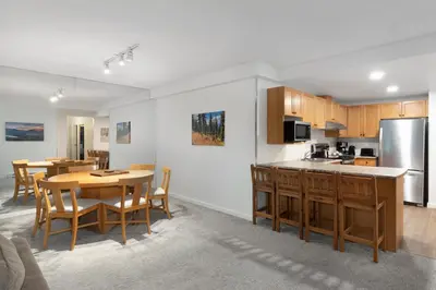 a kitchen and dining room with a table and chairs at The Woodrun Lodge by Whiski Jack in Whistler