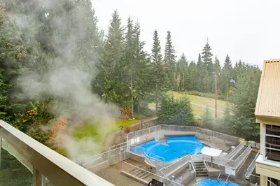 a hot tub on the roof of a building with smoke at The Woodrun Lodge by Whiski Jack in Whistler