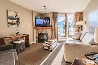 a living room with a couch and a fireplace at Cascade Lodge by Elevate Vacations in Whistler