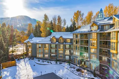 an exterior view of a resort in the mountains with snow at Cascade Lodge by Elevate Vacations in Whistler