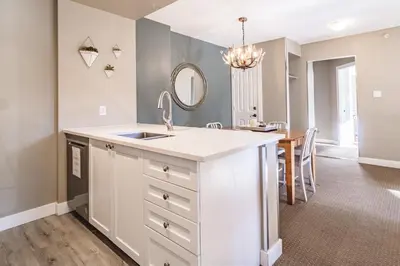 a kitchen with a sink and a dining room at Cascade Lodge by Elevate Vacations in Whistler