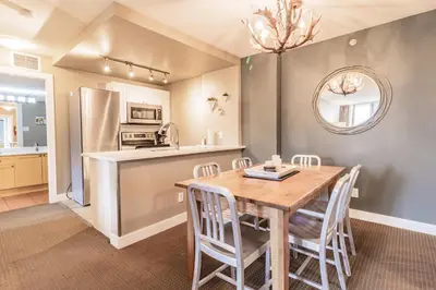 a kitchen and dining room with a wooden table and chairs at Cascade Lodge by Elevate Vacations in Whistler