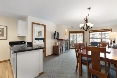 a kitchen and living room with a table and a dining room at The Aspens by Whiski Jack in Whistler