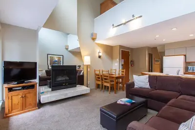 a living room with a couch and a tv at Village Gate House by Whiski Jack in Whistler