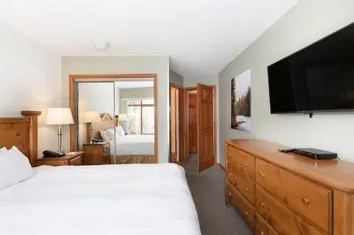 a bedroom with a bed and a flat screen tv at Northstar at Stoney Creek by Whiski Jack in Whistler