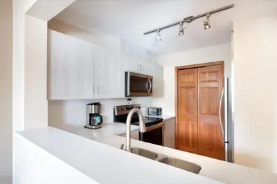 a kitchen with white cabinets and a counter top at Northstar at Stoney Creek by Whiski Jack in Whistler