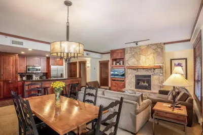 a living room with a table and a couch at First Tracks Lodge, by Lodging Ovations in Whistler