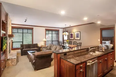 a kitchen and living room with a couch and a table at First Tracks Lodge, by Lodging Ovations in Whistler
