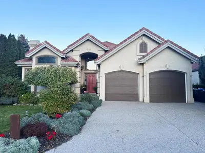 a house with two garage doors and a driveway at Quail Ridge in Kelowna