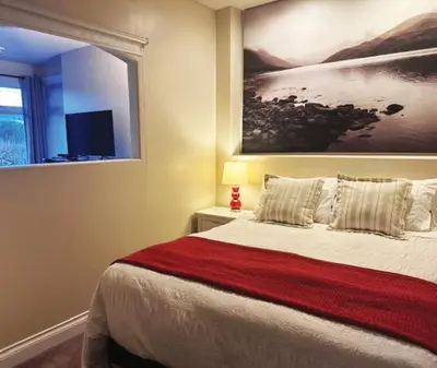 a bedroom with a bed with a painting on the wall at Quail Ridge in Kelowna