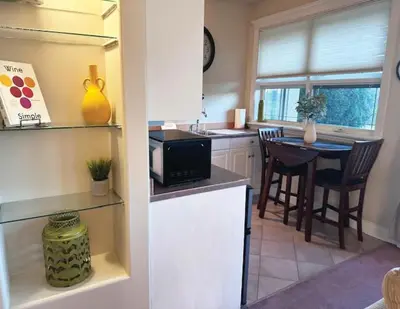 a kitchen with a microwave and a table with chairs at Quail Ridge in Kelowna