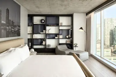 a bedroom with a white bed and a large window at the DOUGLAS, Autograph Collection in Vancouver