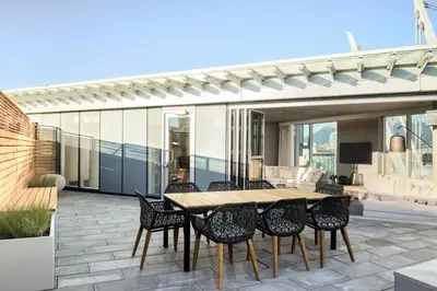 a patio with a wooden table and chairs at the DOUGLAS, Autograph Collection in Vancouver