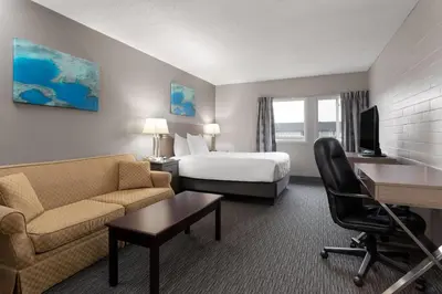 a hotel room with a bed and a desk at Travelodge by Wyndham Grande Prairie in Grande Prairie